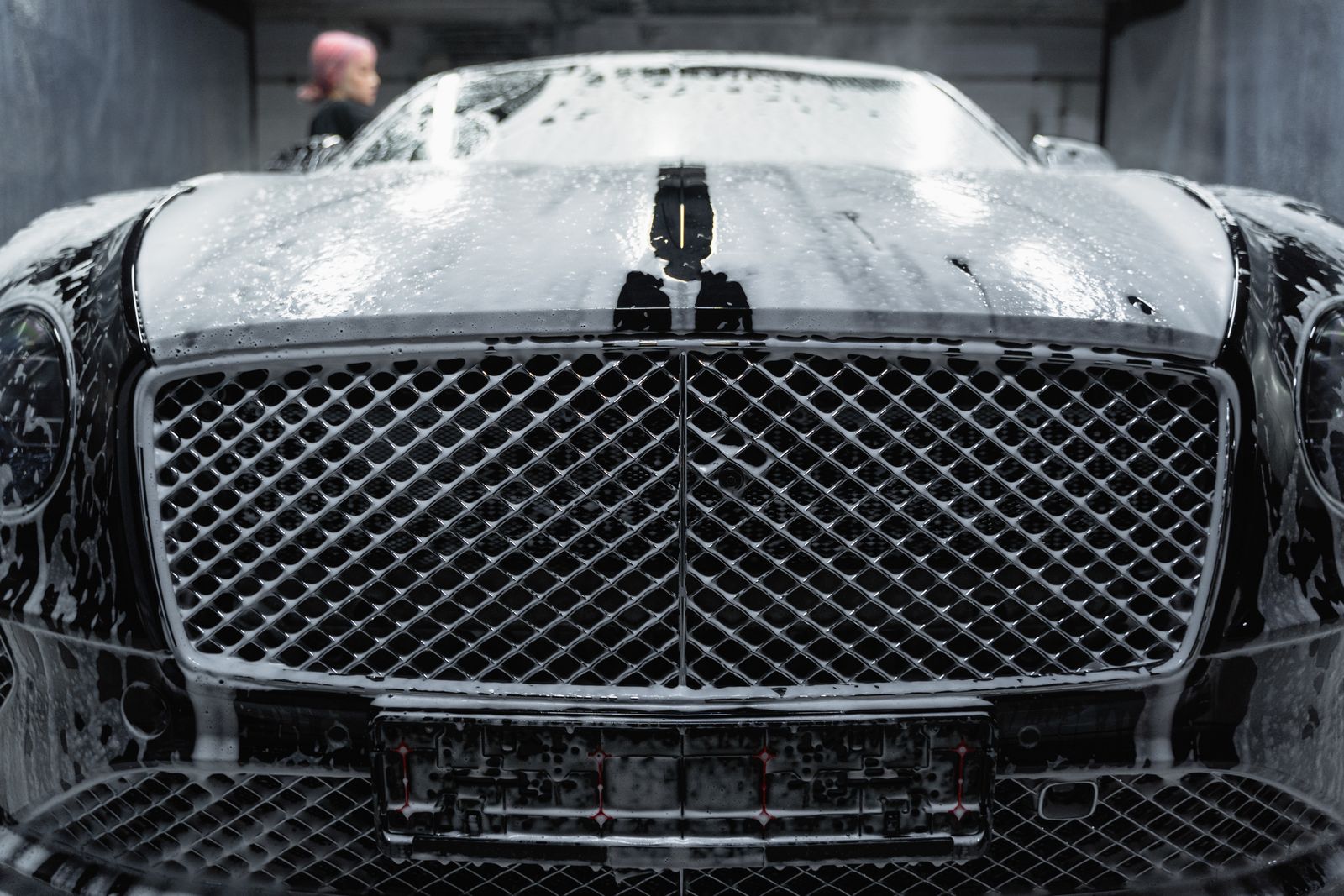 Snow foam clinging to a Bentley grille