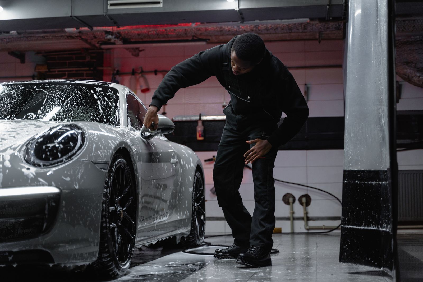 Rinsing suds off a Porsche 911 during a full wash